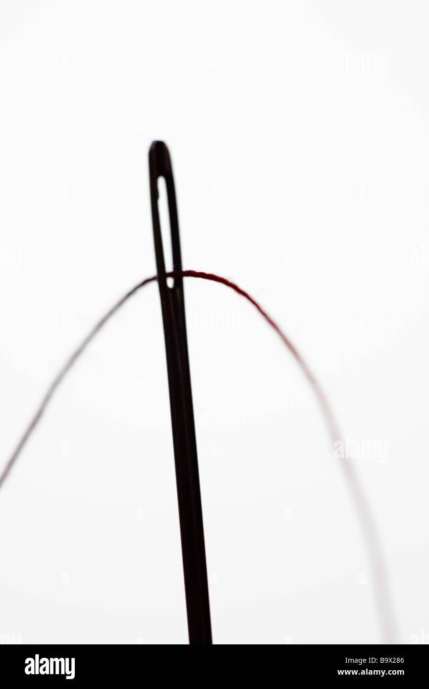 Threading a needle in silhouette Stock Photo