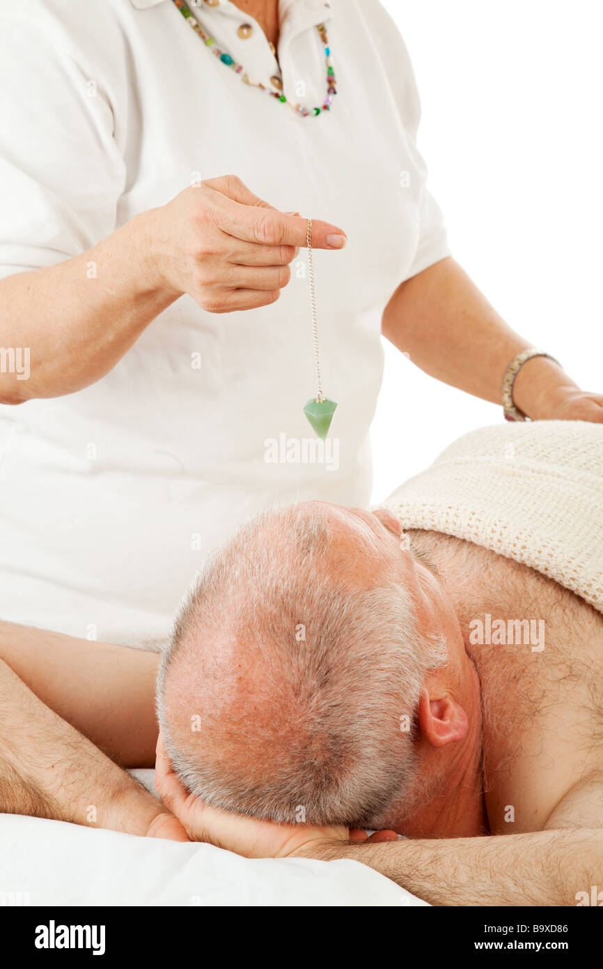 Healer uses a jade pendulum to unblock her patient s energy centers Stock Photo