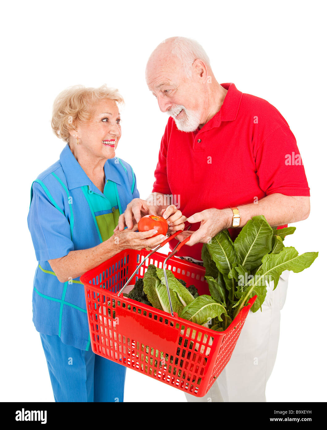 Adorable senior couple enjoys shopping for healthy fresh produce together Isolated on white  Stock Photo