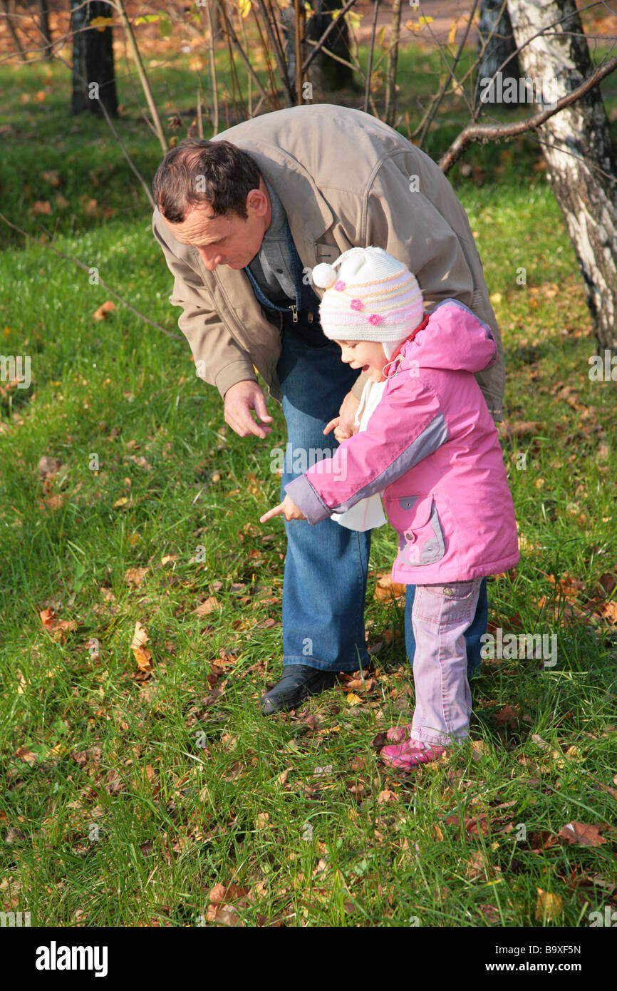 Grandfather with  granddaughter outdoor look downward Stock Photo