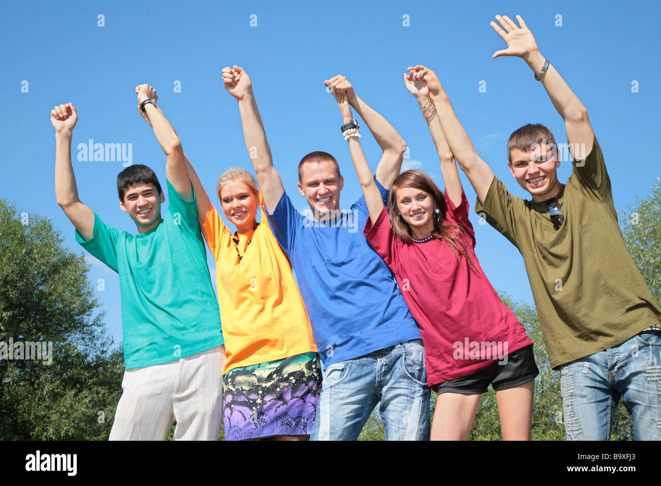 Люди в разноцветных футболках. Фото подростка с поднятой рукой. Школьник тянет руку вверх. Подросток поднял. Подросток поднял.