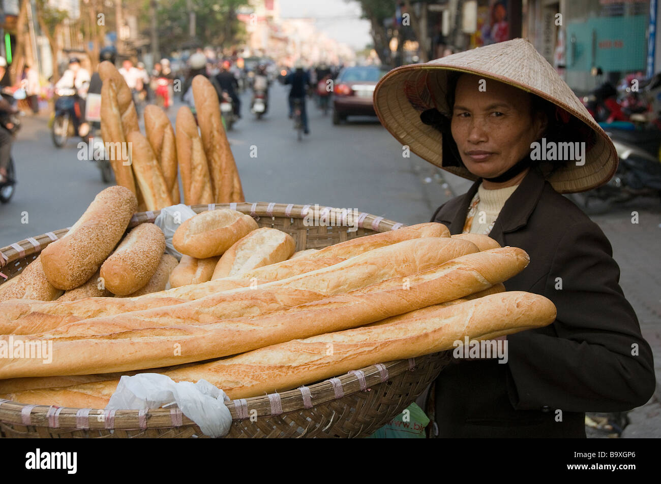 A vintage photo of a French baguette being sold on the streets of Vietnam, with a vendor holding a basket of fresh herbs and chili sauce