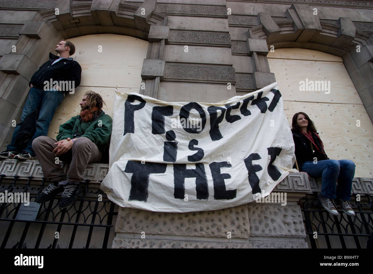 G20 demonstration London with demonstrators holding property is theft banner at Bank London, UK Stock Photo