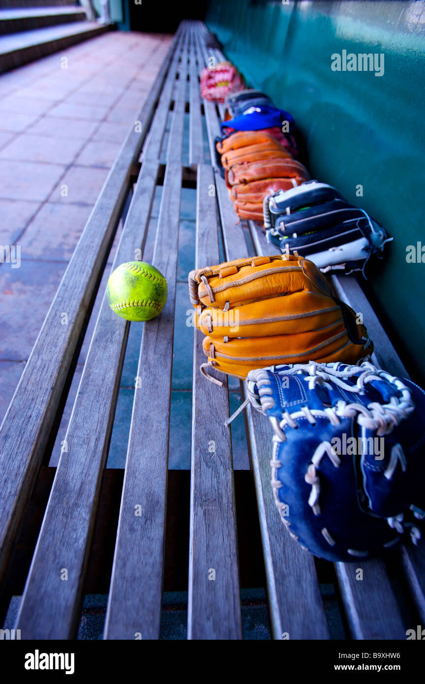 Baseball gloves and ball on bench in dugout Stock Photo Alamy