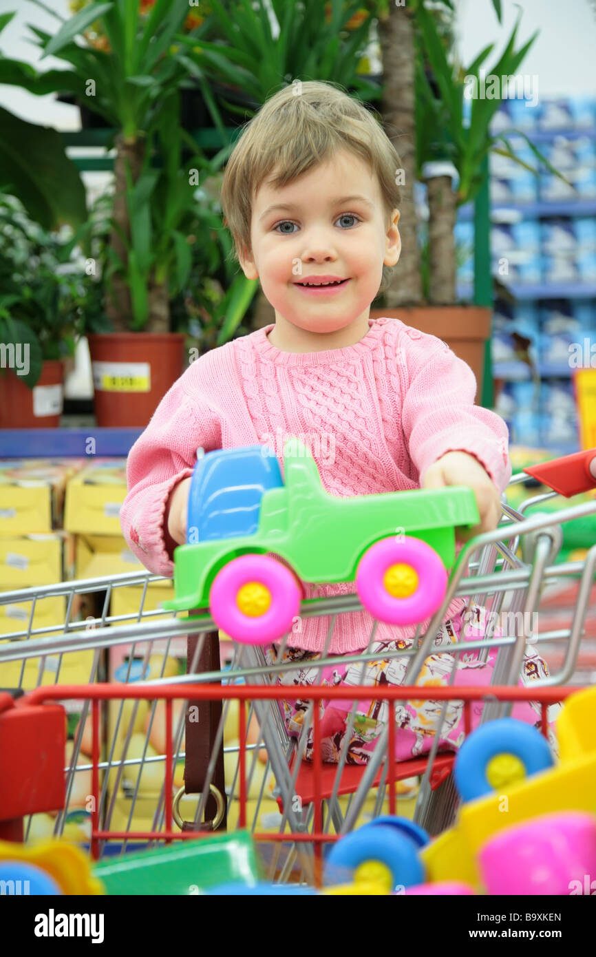 child in shoppingcart with toy car Stock Photo Alamy