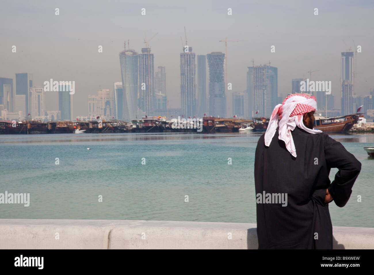 Arab Man and Skyscraper Construction Skyline in Doha Qatar Stock Photo