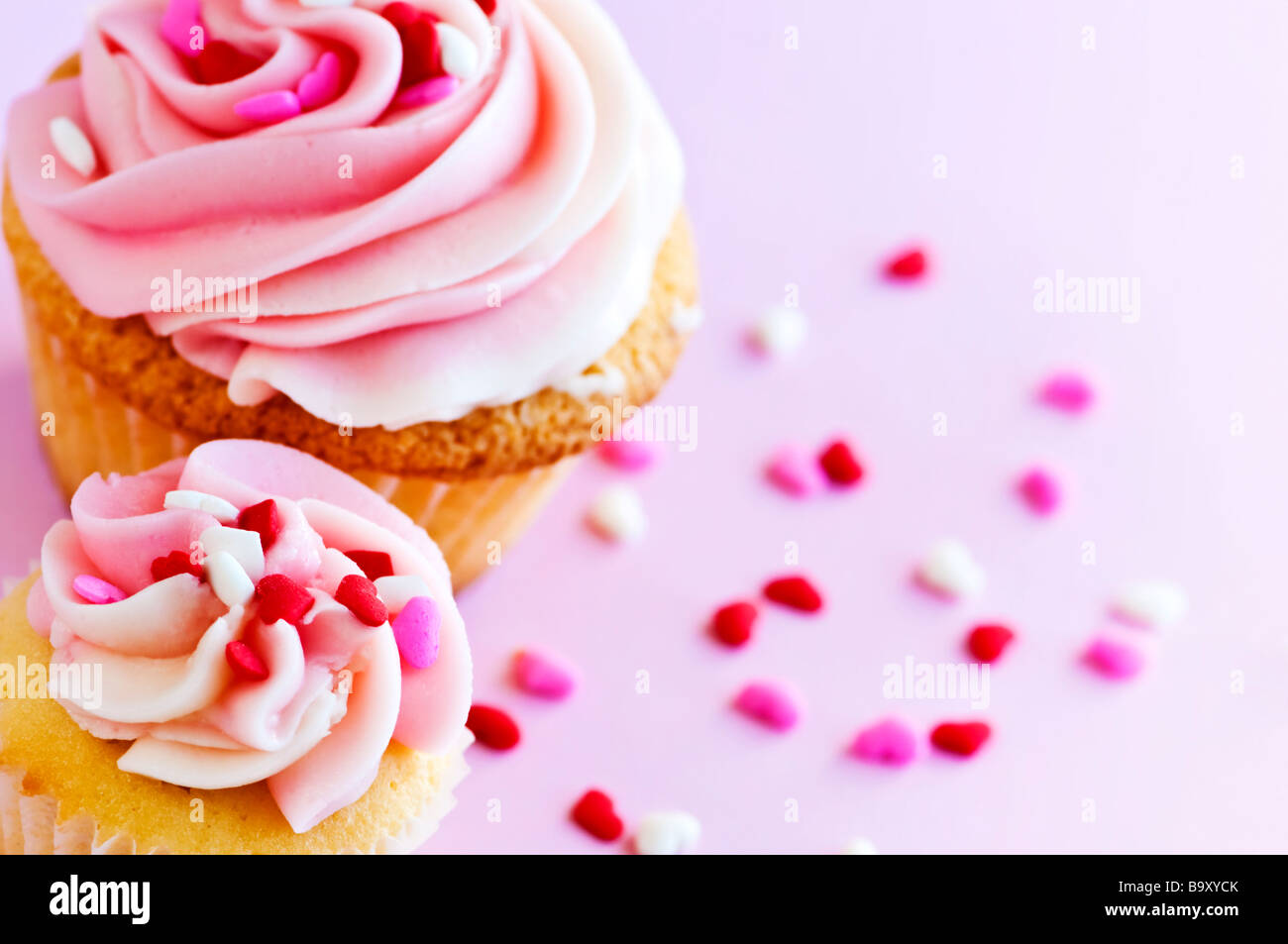 Big and small cupcakes with icing and sprinkles Stock Photo Alamy