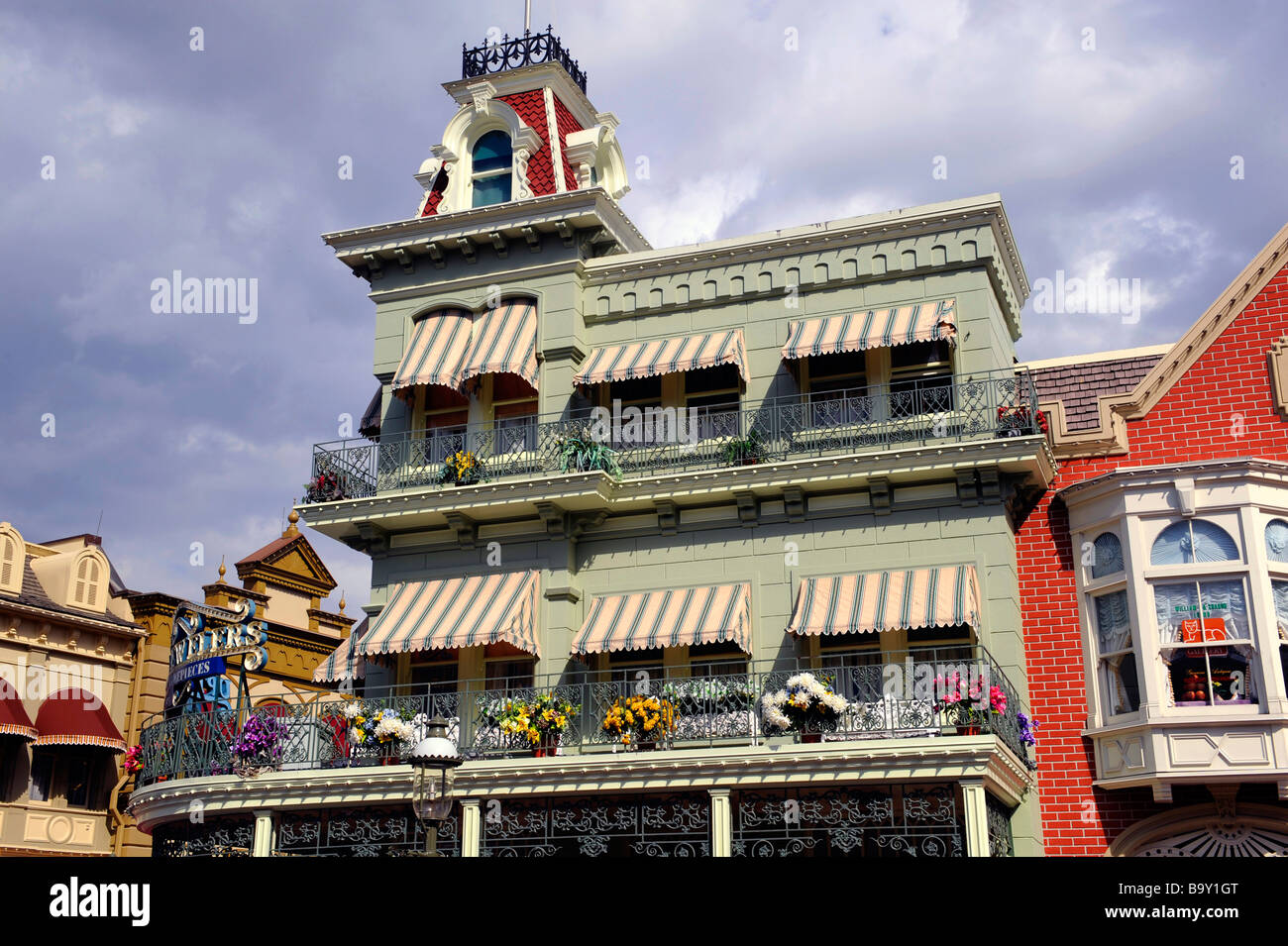 Store with flowers in window boxes along Main Street at Walt Disney Magic Kingdom Theme Park Orlando Florida Central Stock Photo