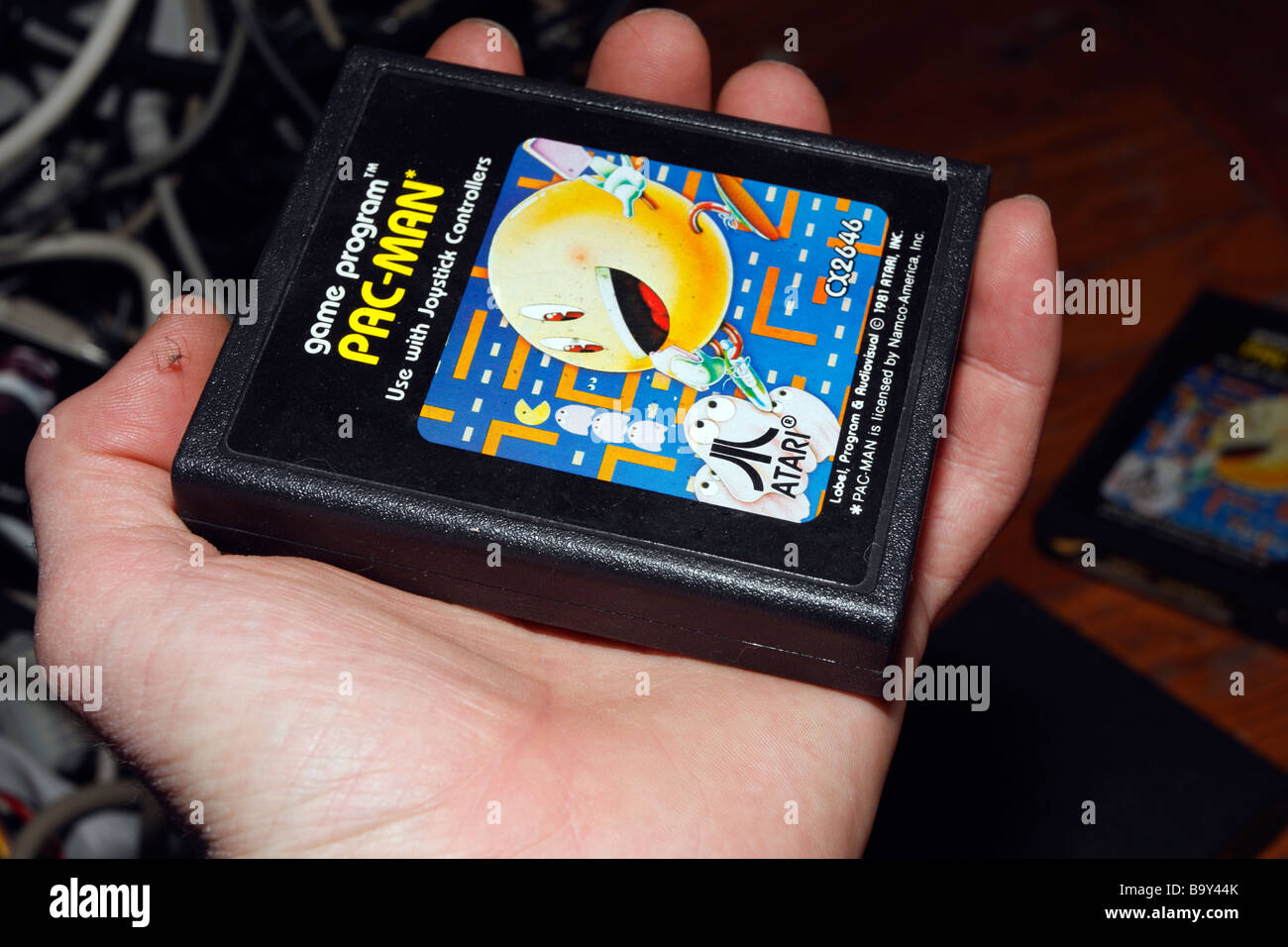 Hand and PacMan Pac-man console game cartridge for Atari Stock Photo - Alamy