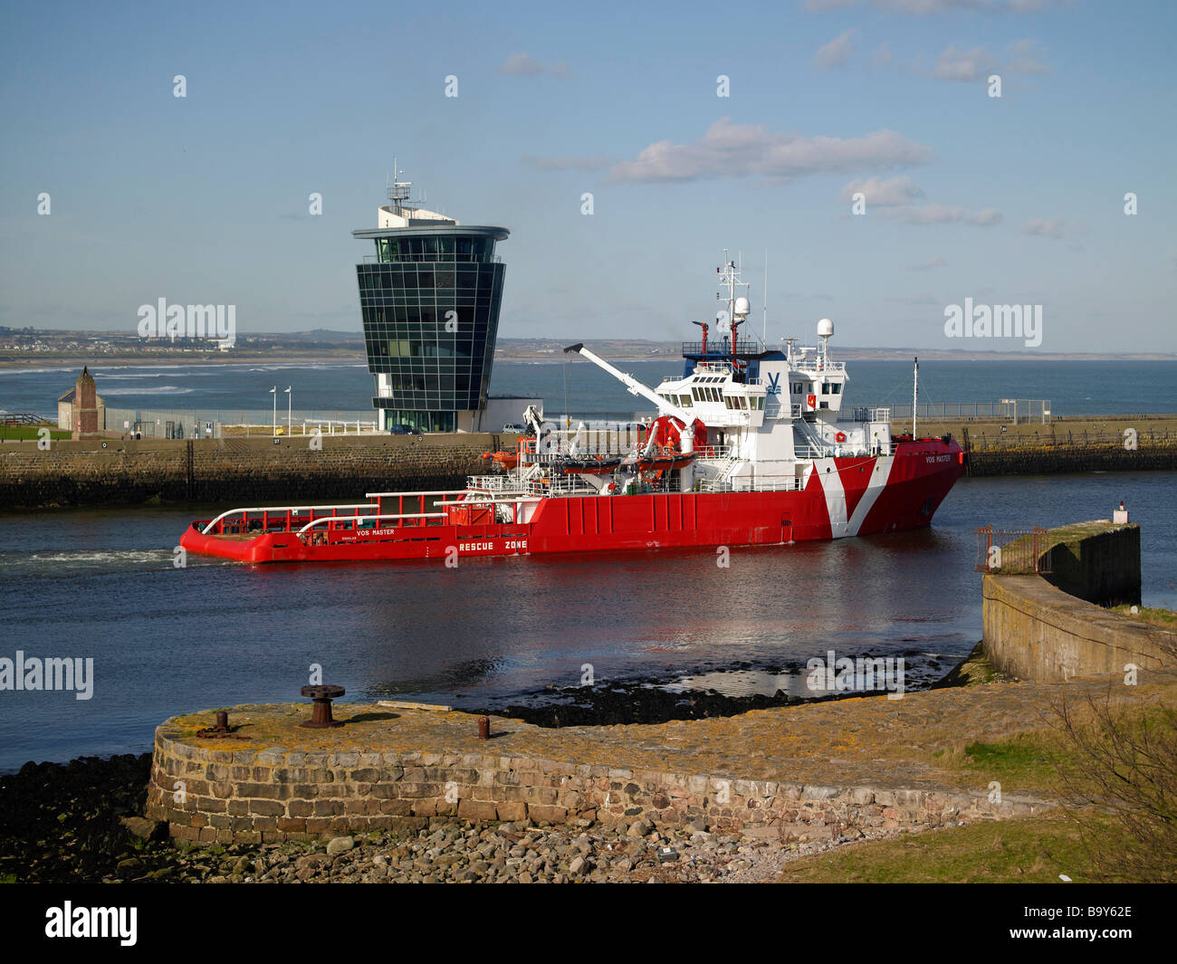 Aberdeen Harbour, North East Scotland, with a North Sea support ship passing the Marine Operations Centre Stock Photo