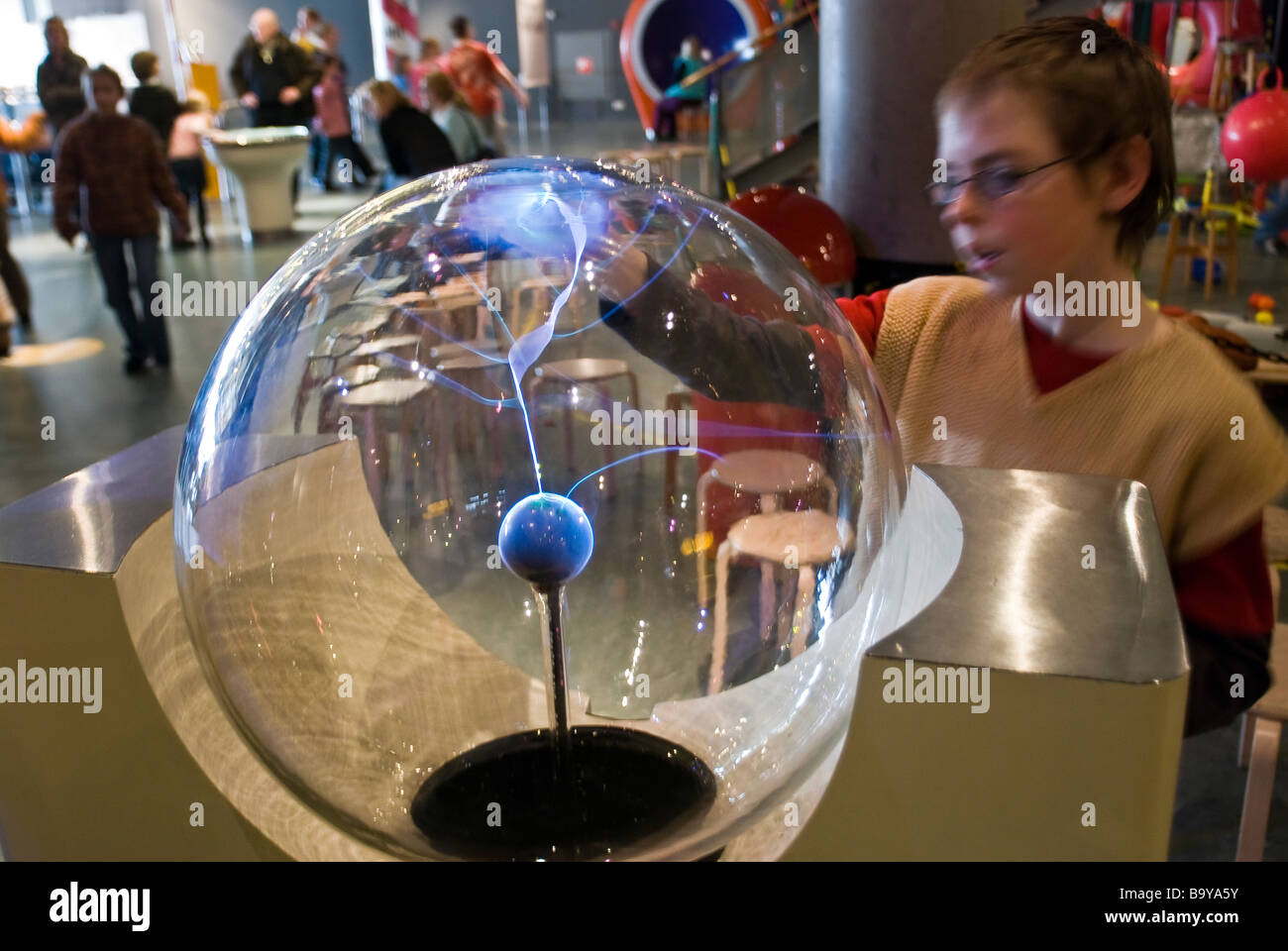 Boy experimenting with a plasma lamp at the NEMO children's science museum in Amsterdam, The Netherlands Stock Photo