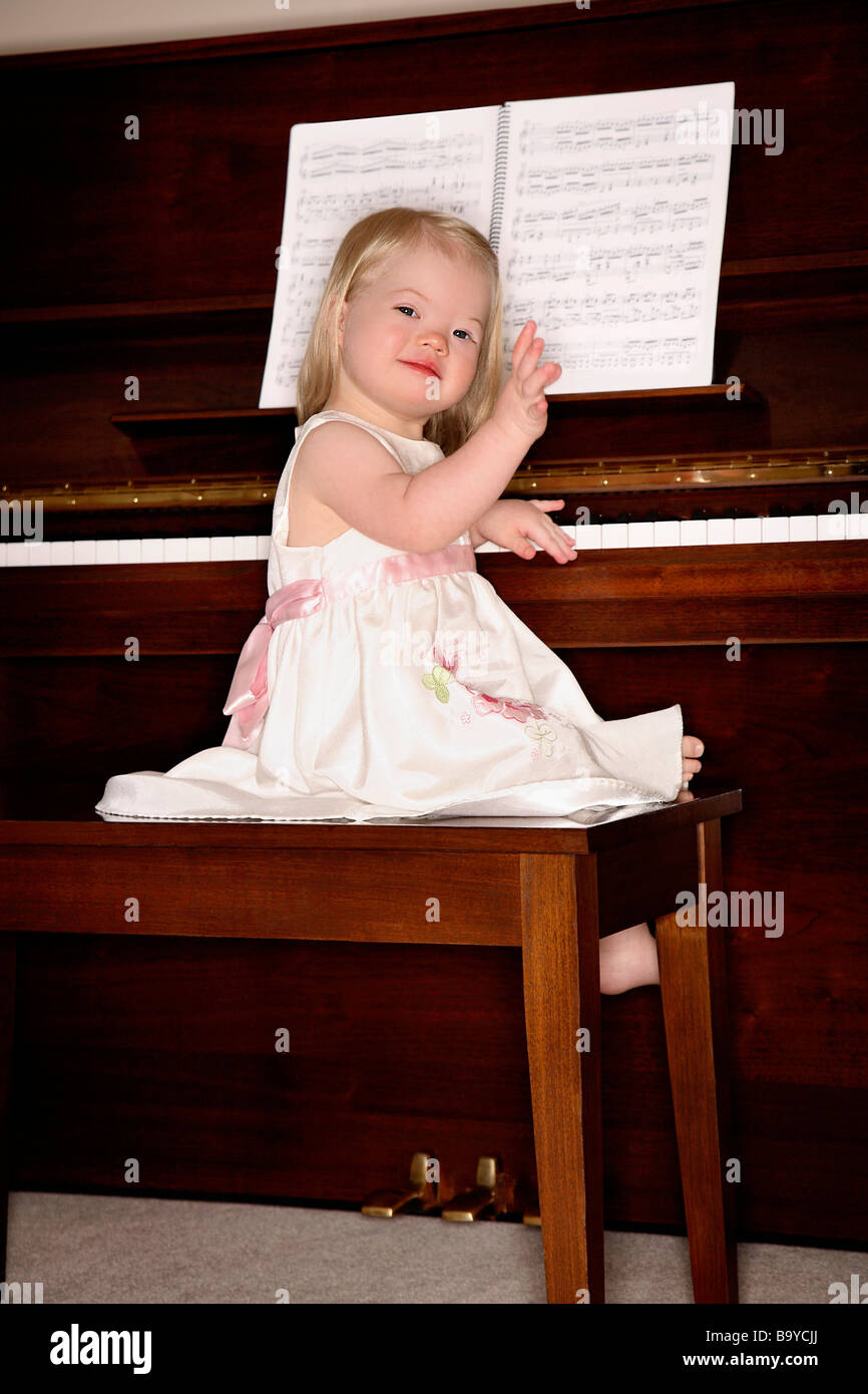 Girl sitting on piano bench Stock Photo Alamy