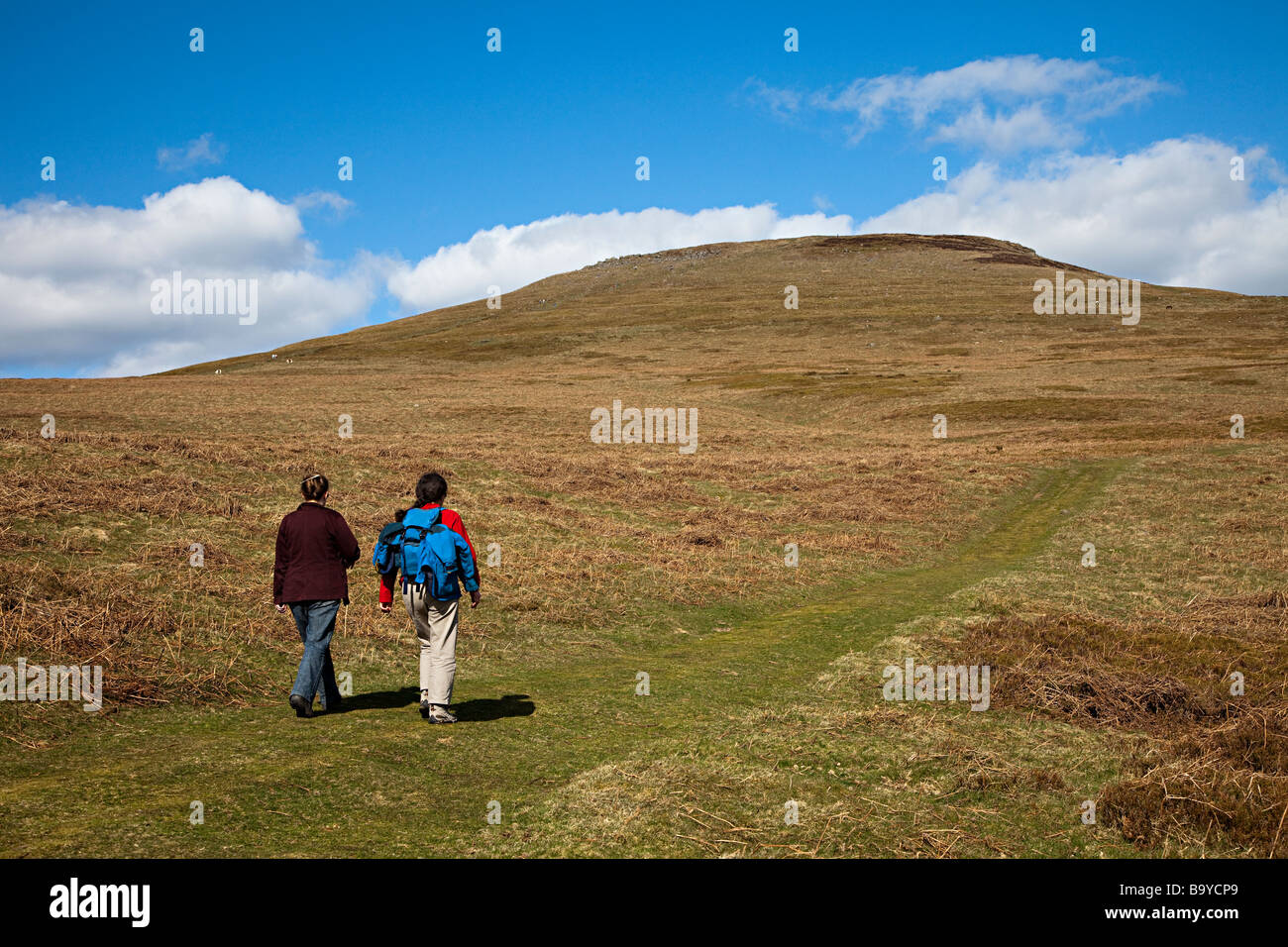 Two female walkers on footpath on Sugarloaf mountain Wales UK Stock Photo