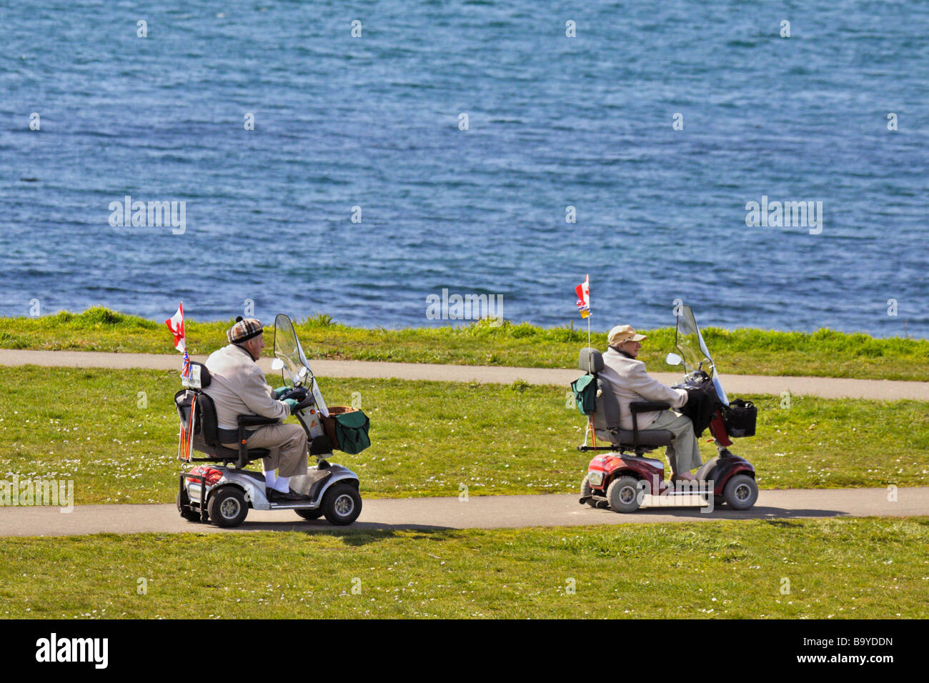 Senior couple on scooters at Dallas road waterfront Victoria British Columbia Canada Stock Photo