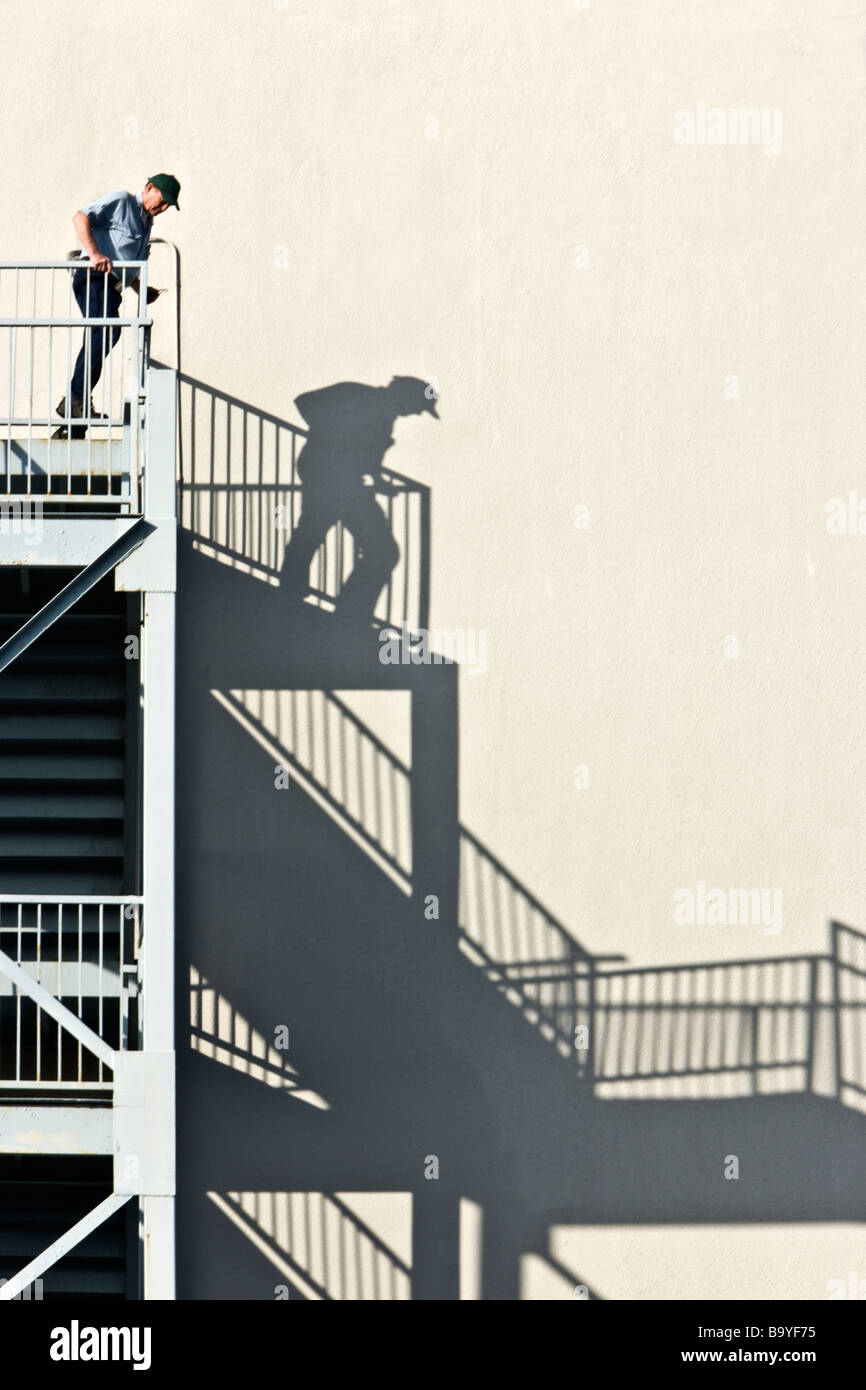 Male person using  fire escape, shadow image. Stock Photo