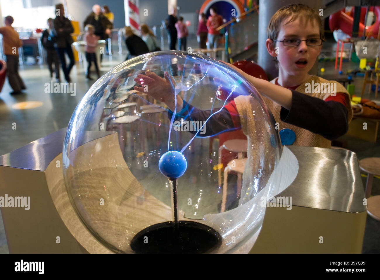 Boy experimenting with a plasma lamp at the NEMO children's science museum in Amsterdam, The Netherlands Stock Photo
