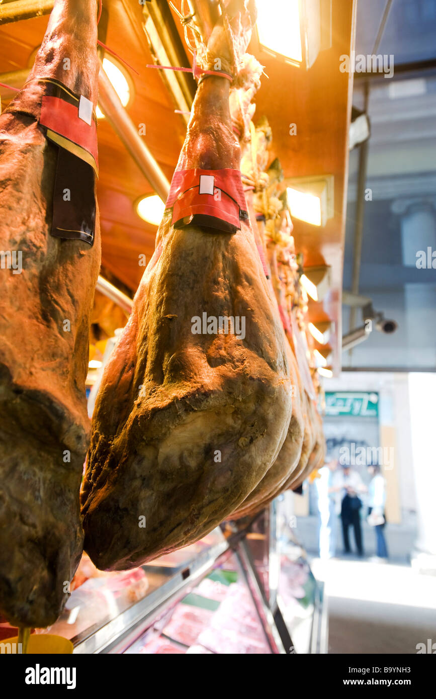 Smoked pork legs hanging on display in butcher's shop Stock Photo
