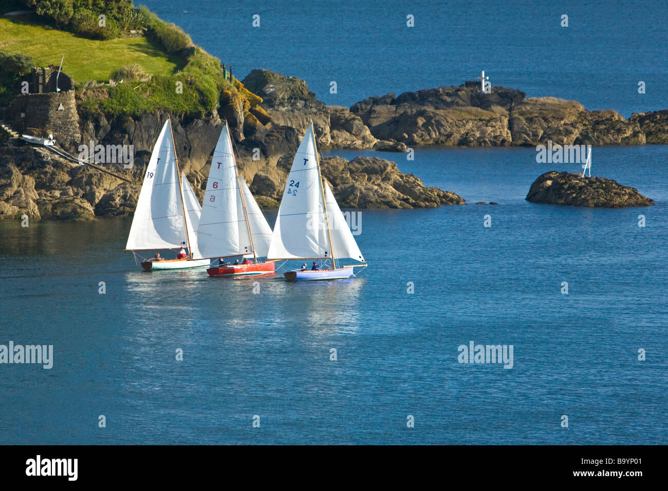 Troy class sailing boats in River Fowey estuary heads out to sea past