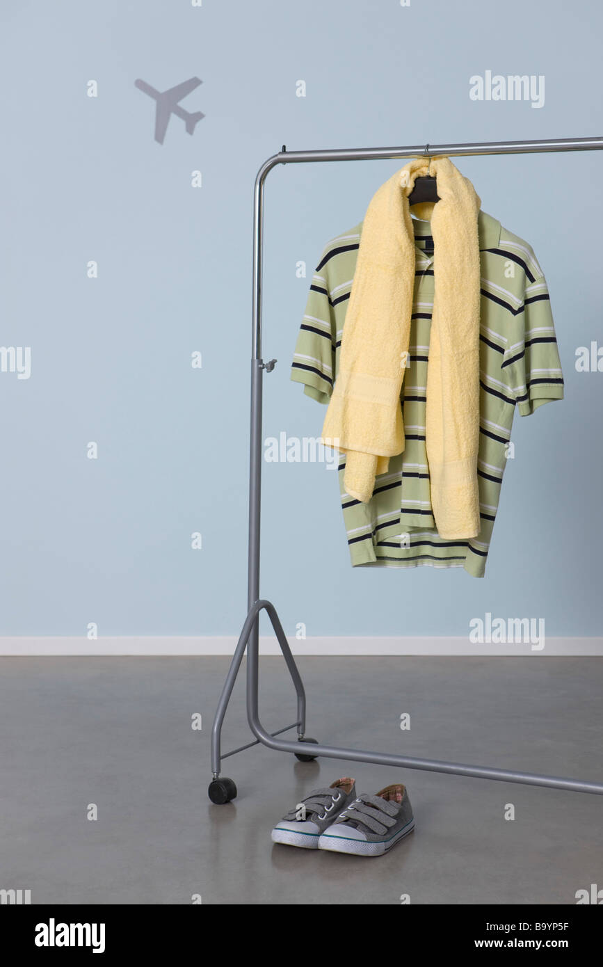 Man's casual clothes hanging on clothes rack, airplane graphic in background Stock Photo