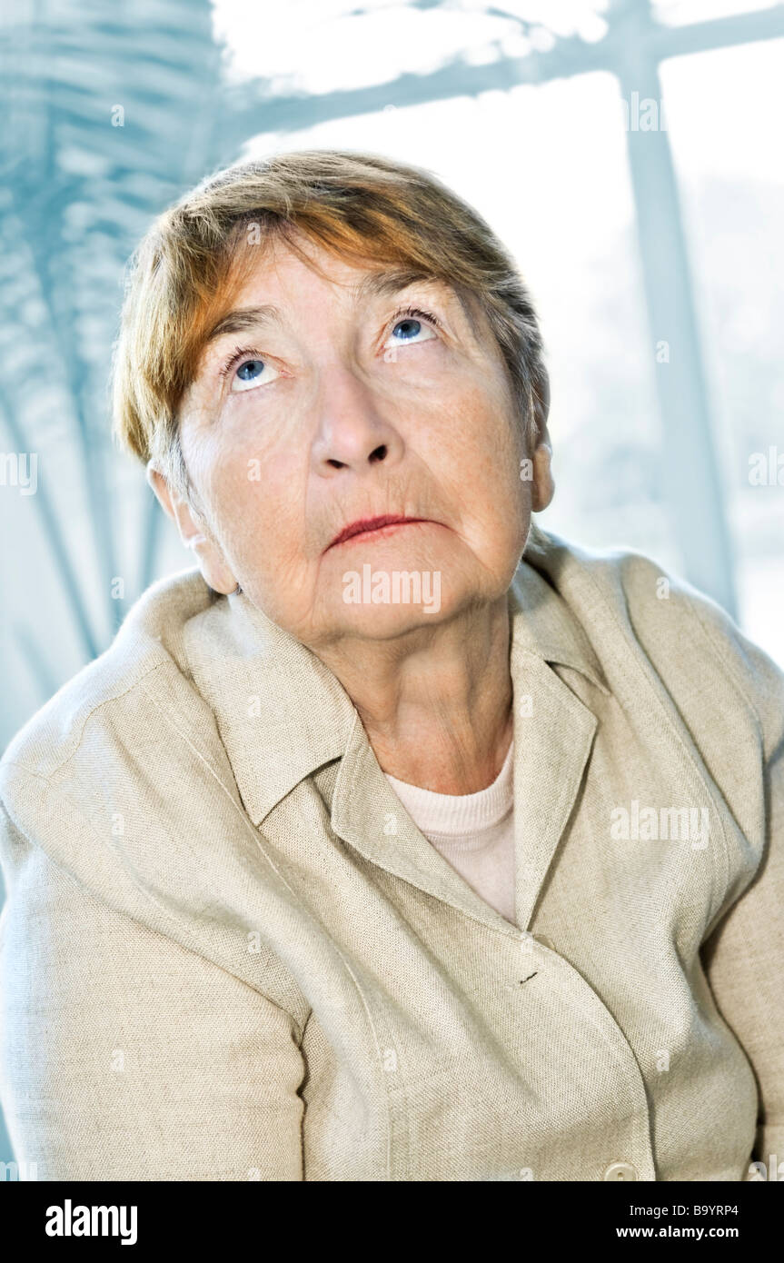 Senior woman looking up with abstract background Stock Photo
