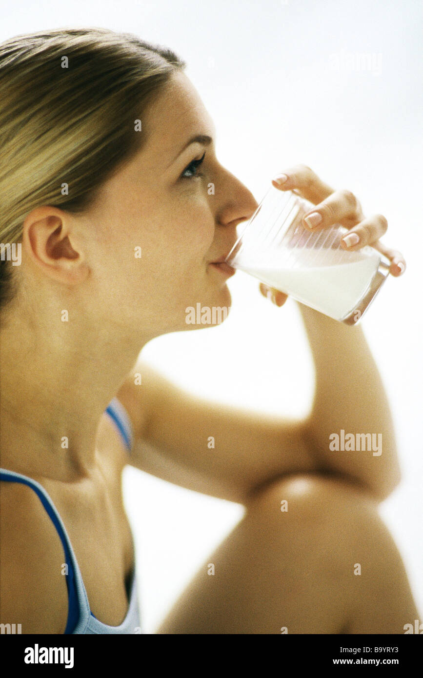 Woman drinking glass of milk, side view Stock Photo