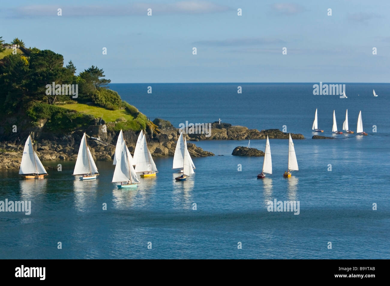 Troy class sailing boats in River Fowey estuary heads out to sea past