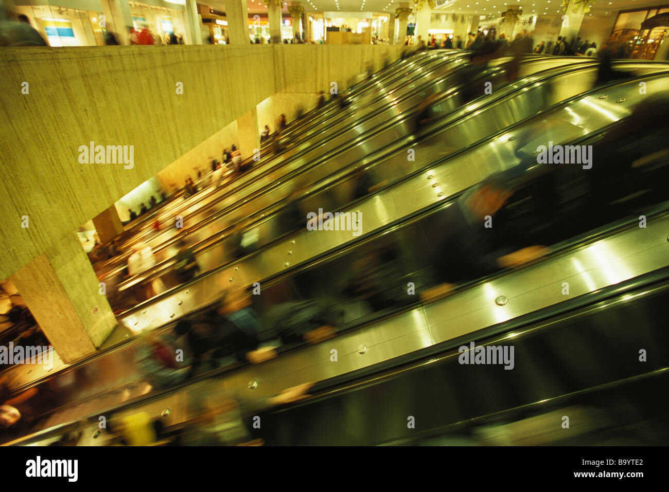 Escalators in crowded shopping mall Stock Photo