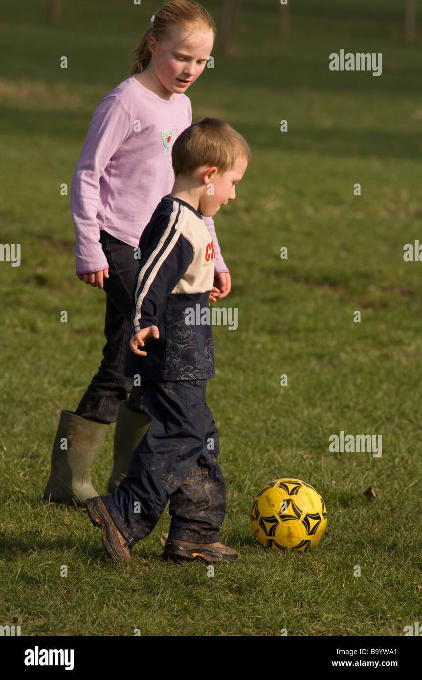 Children playing football in garden England UK Europe Stock Photo