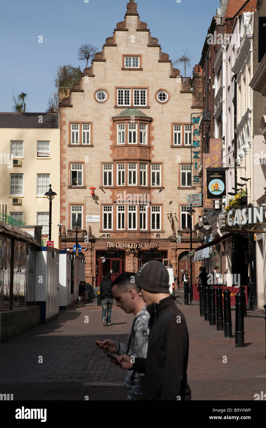 Young men texting in Leicester Square, London Stock Photo