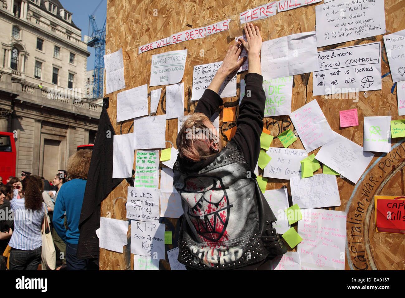 Man posting a protest message on a board outside the Bank of England during the 2009 G20 summit, London, UK. Stock Photo