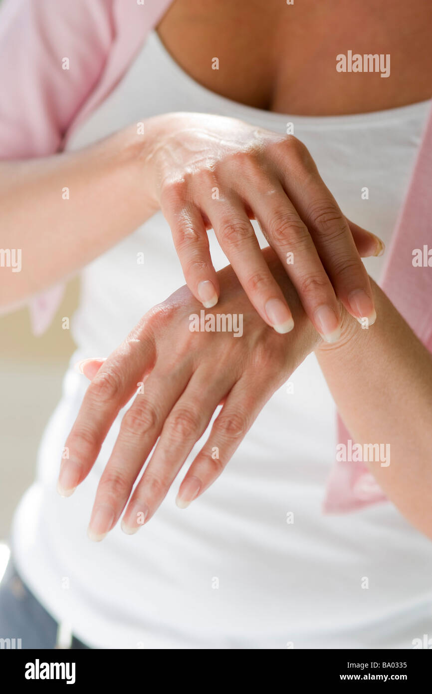 Portrait of mature woman massaging hands Stock Photo