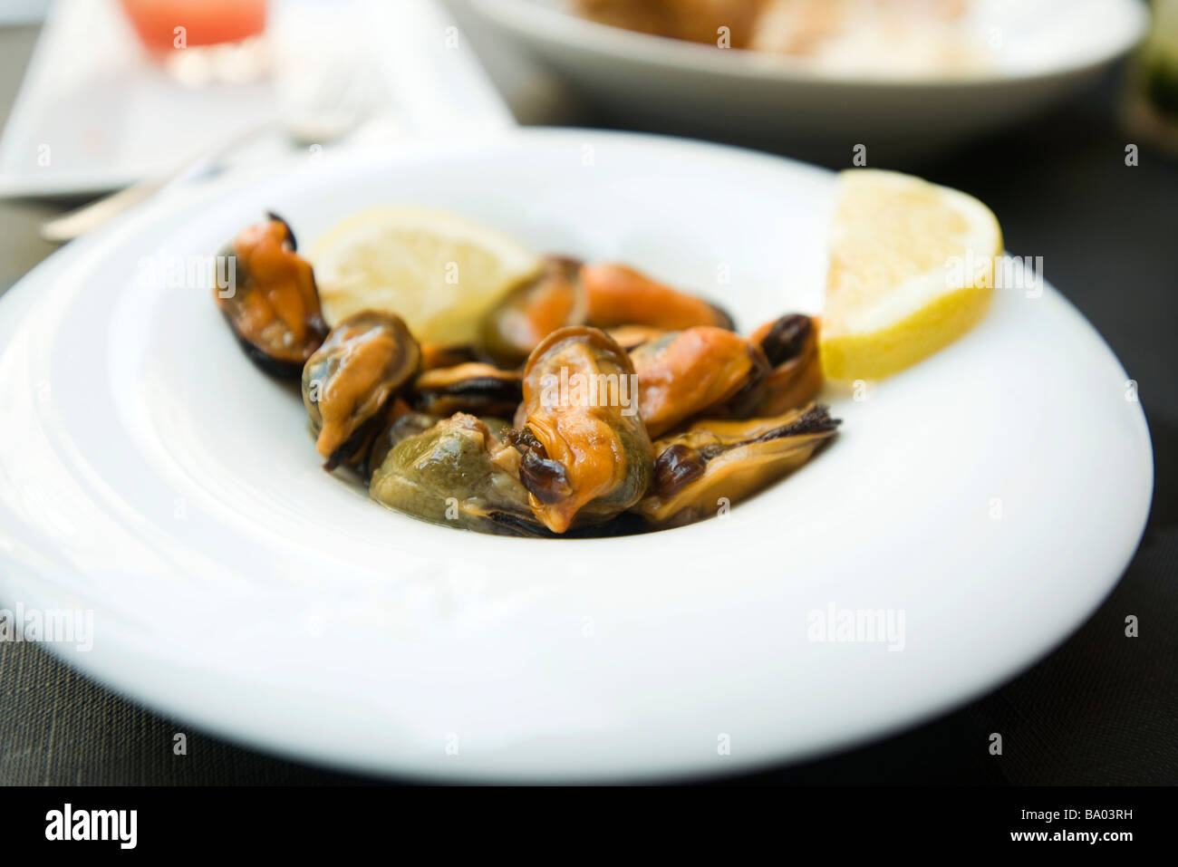 Steamed mussels garnished with lemon slices Stock Photo Alamy