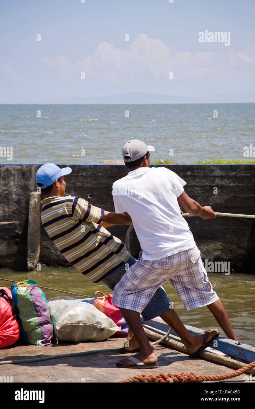 Men pulling a boat into the dock of San Jorge, Nicaragua. Stock Photo