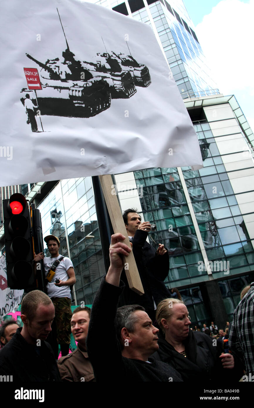 Banksy holds onto traffic light at G20 demonstration in London grafitti artist Stock Photo