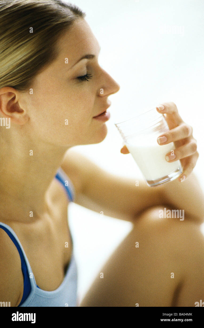 Woman drinking glass of milk, side view Stock Photo