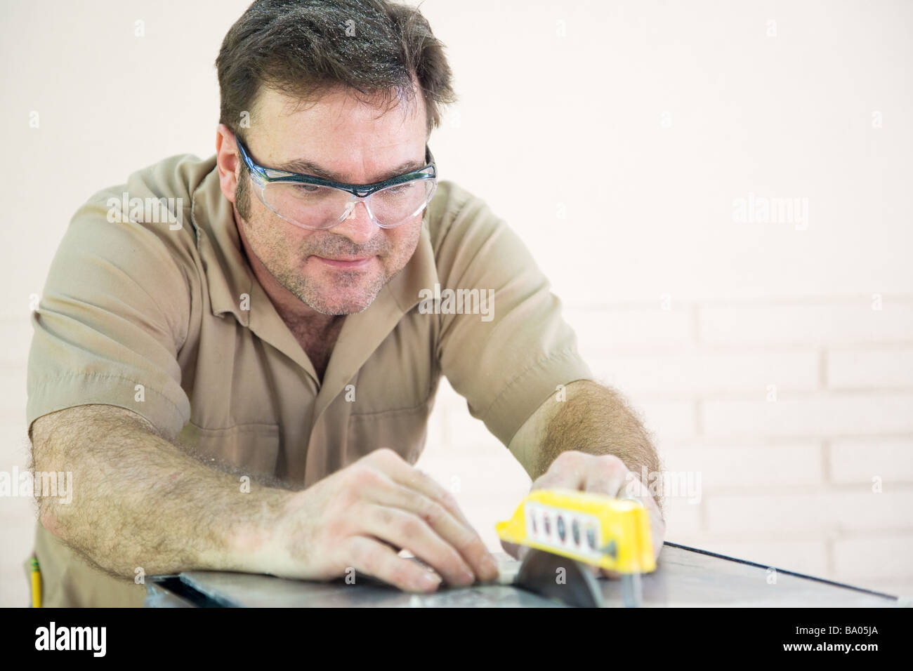 Handsome tile cutter using table saw to cut ceramic tile Stock Photo
