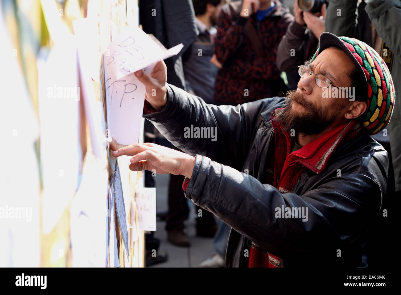 Protester posting a message on a board outside the Bank of England during the 2009 G20 summit, London, UK. Stock Photo