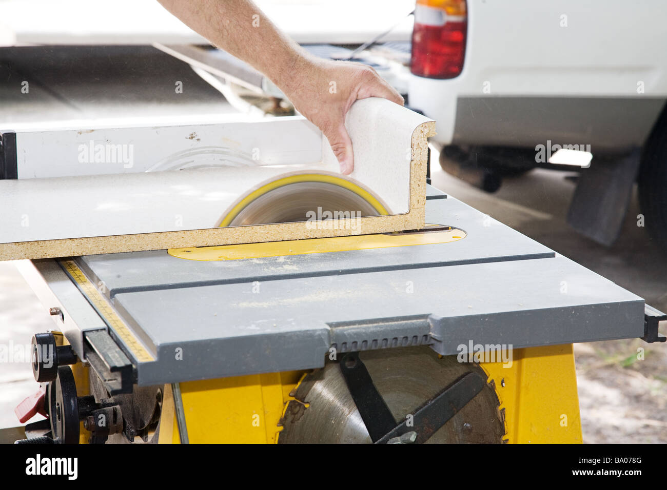 Closeup of a carpenter cutting through laminate counter top with a
