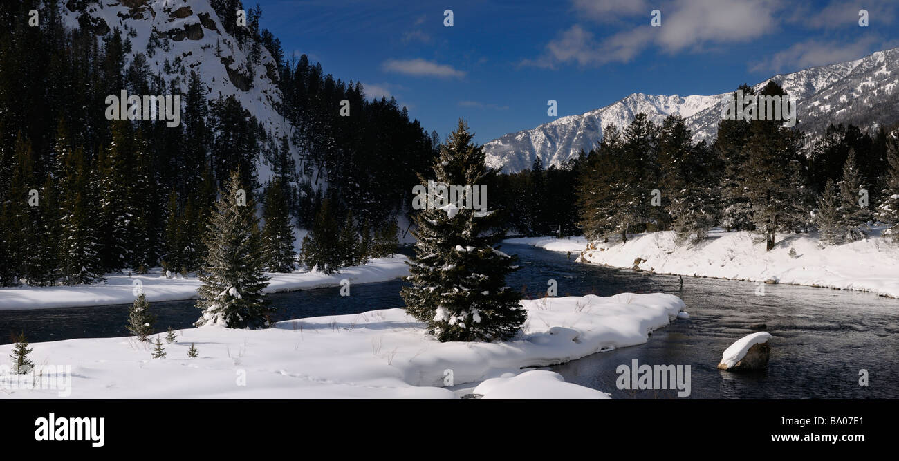 Panorama of Madison River in winter with men fly fishing with snow covered Rocky mountain Madison Range Montana Stock Photo