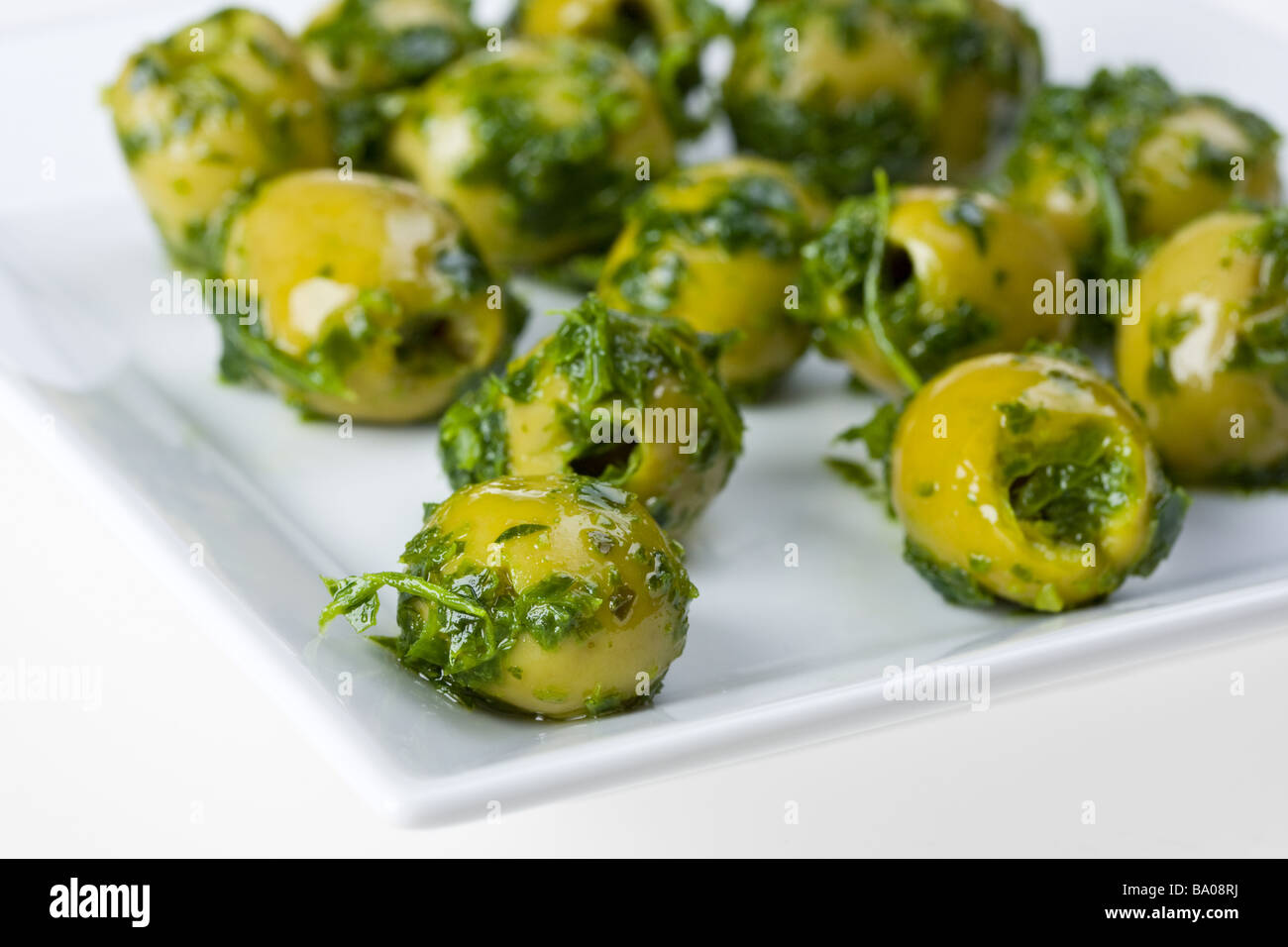 olives on a square white plate Stock Photo Alamy