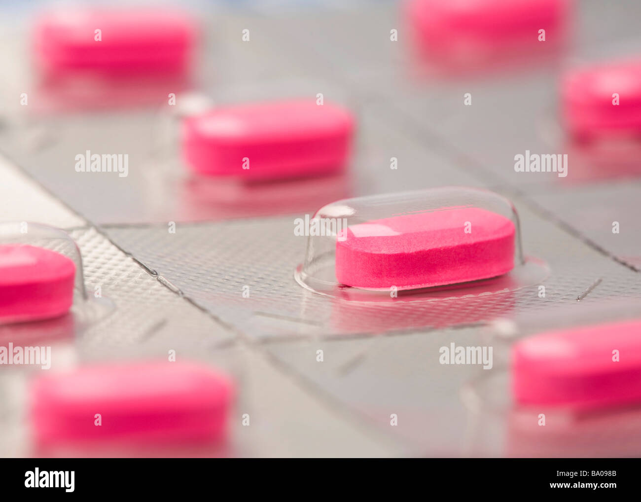 Individually wrapped pink medicine caplets Stock Photo