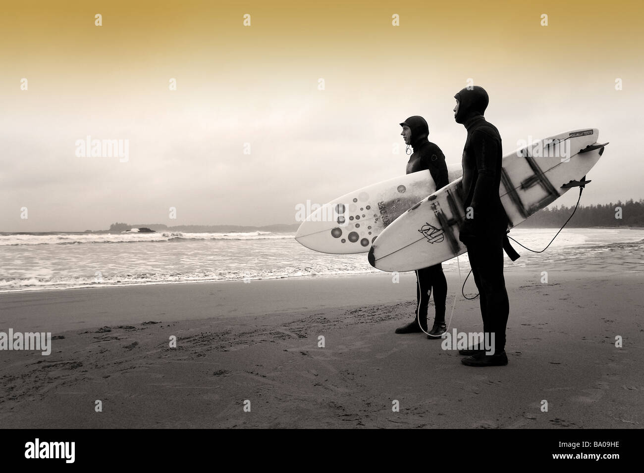 Two surfers on the beach at Chesterman's Beach near Tofino, on Vancouver Island, British Columbia, Canada. Stock Photo