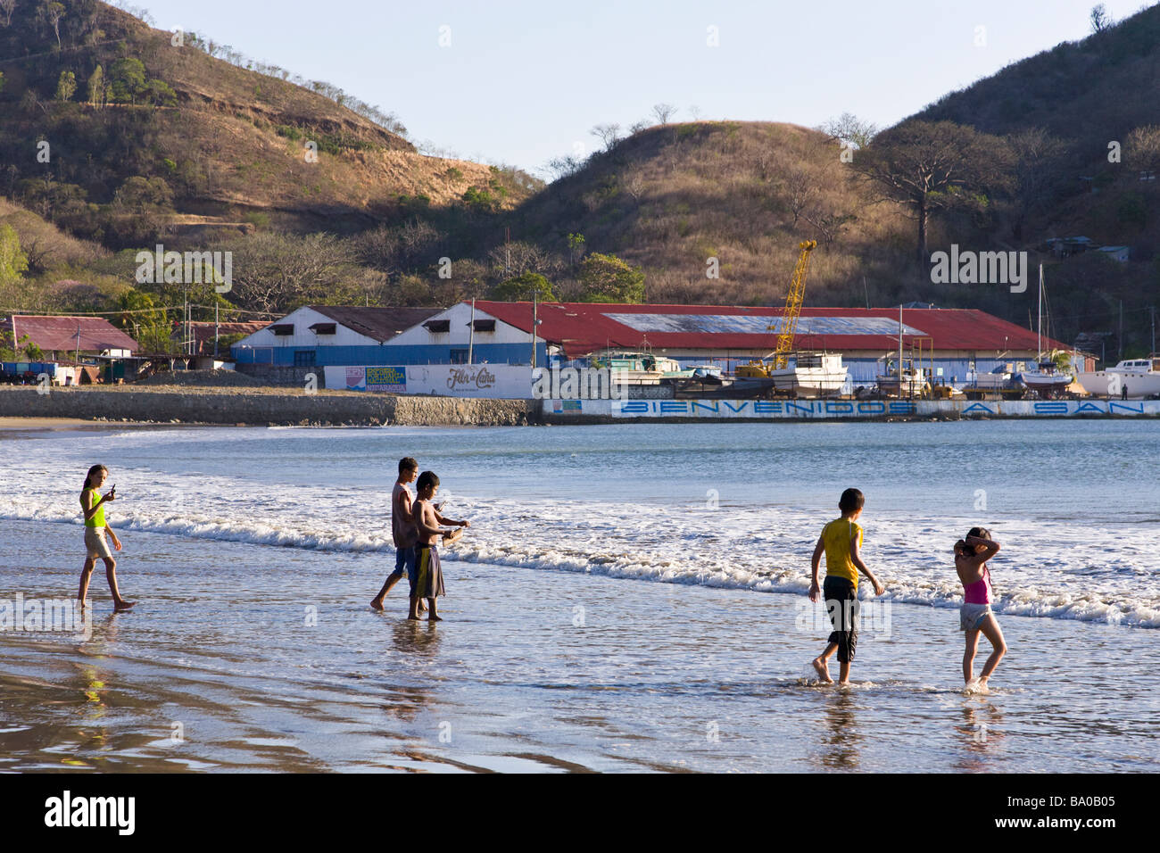 Children walking into the surf on the beach of San Juan del Sur