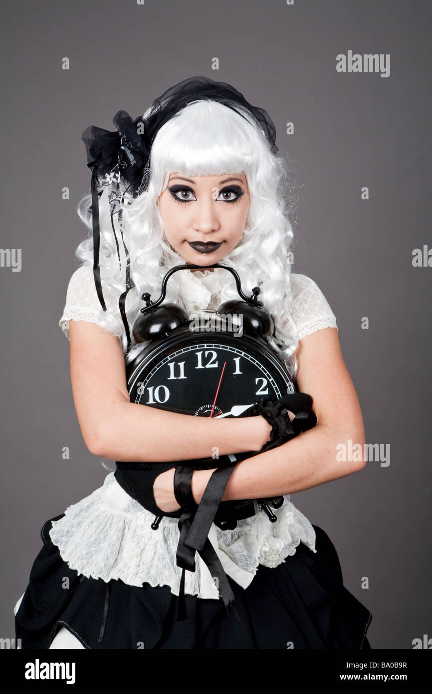 Gothic dressed teenager holding an alarm clock Stock Photo