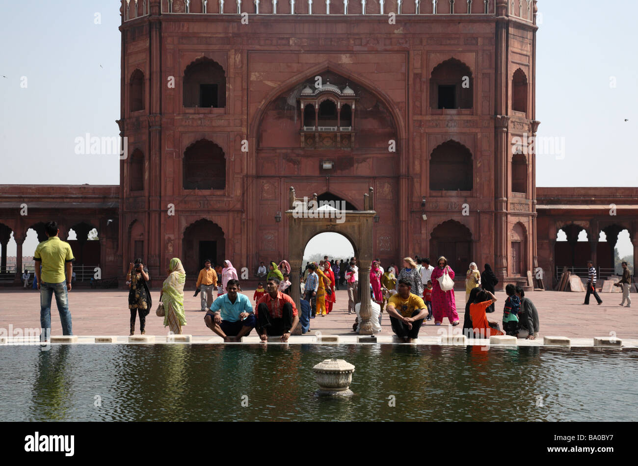 People sit around a fountain at Jama Masjid Mosque, Old Delhi, India Stock Photo
