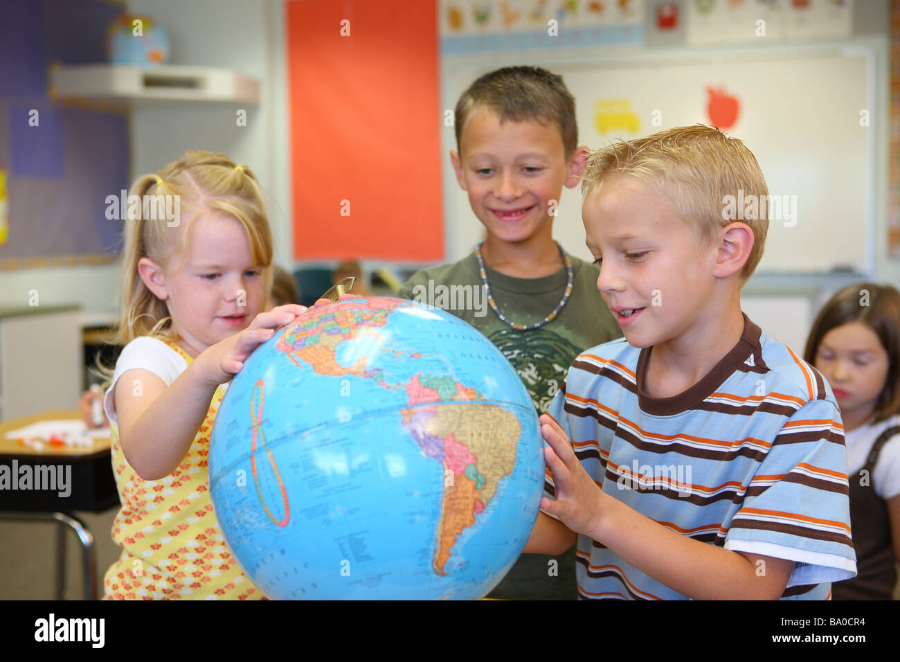 School children looking at globe Stock Photo