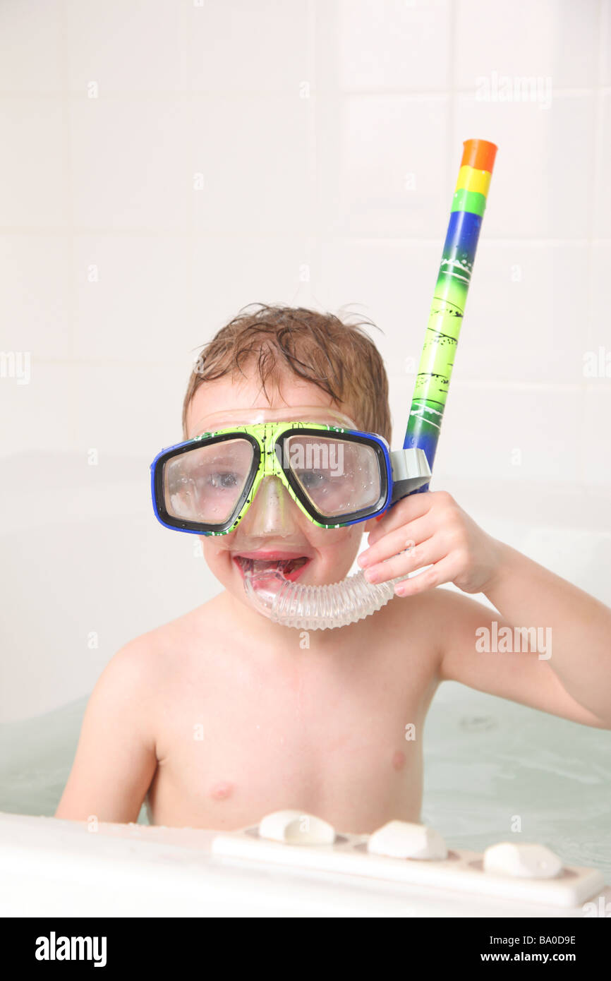 Young boy in bathtub with snorkel gear Stock Photo