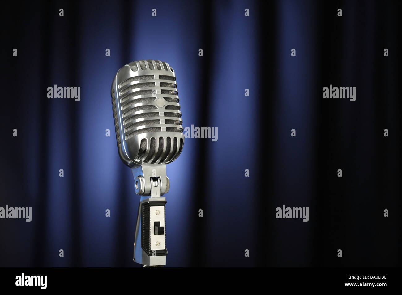Vintage microphone with dark blue curtain background Stock Photo