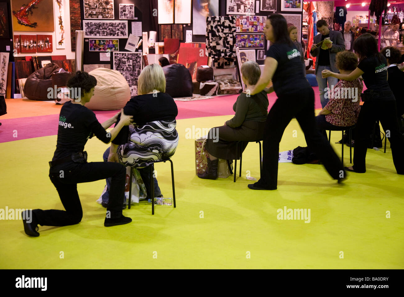 Visitors receive a massage at the The Ideal Home Show Exhibition, Earls Court. London. Stock Photo