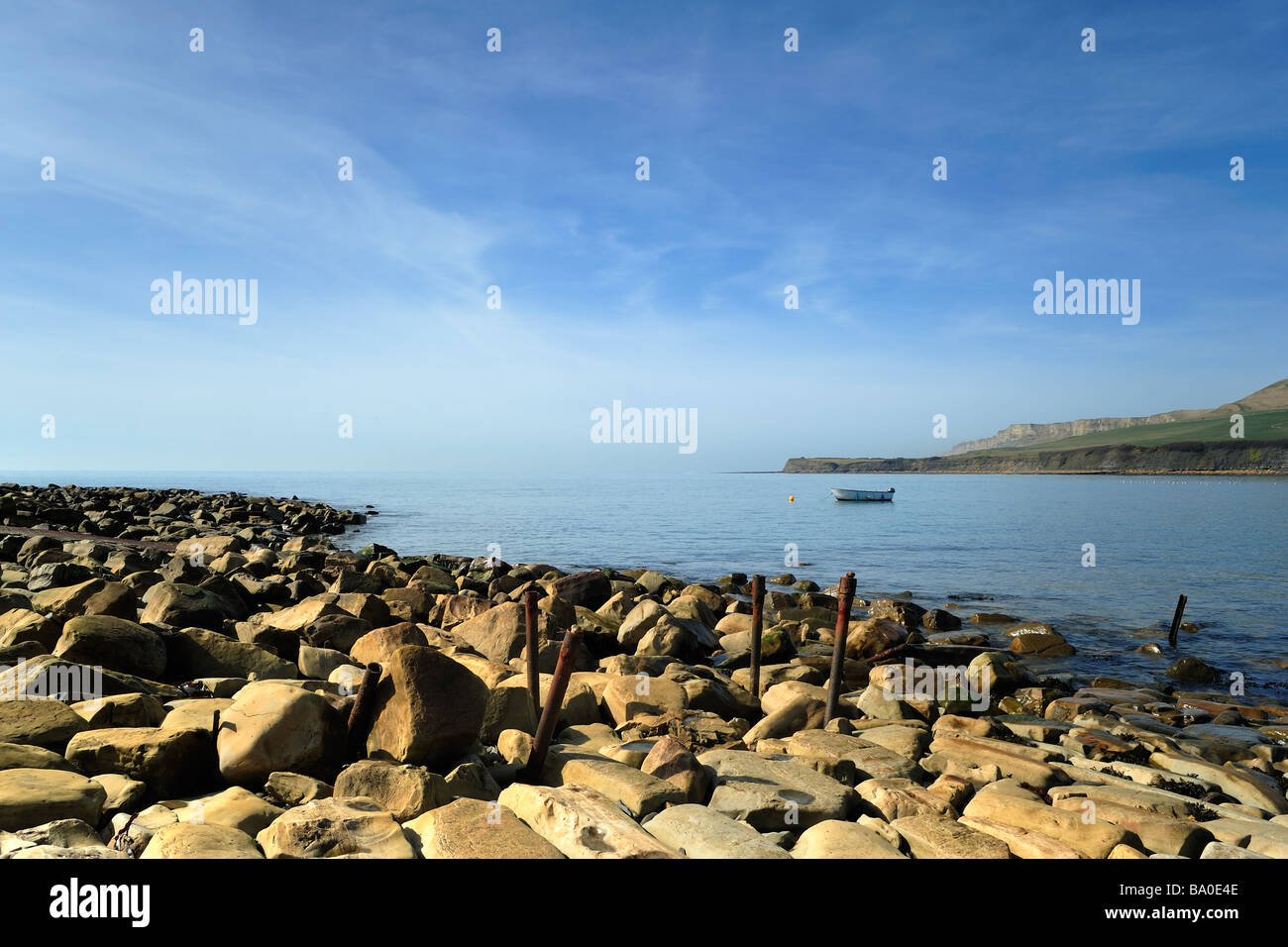 KIMMERIDGE BAY, DORSET, UK- MARCH 16, 2009:  View of an empty rocky beach with dinghy moored in the bay Stock Photo